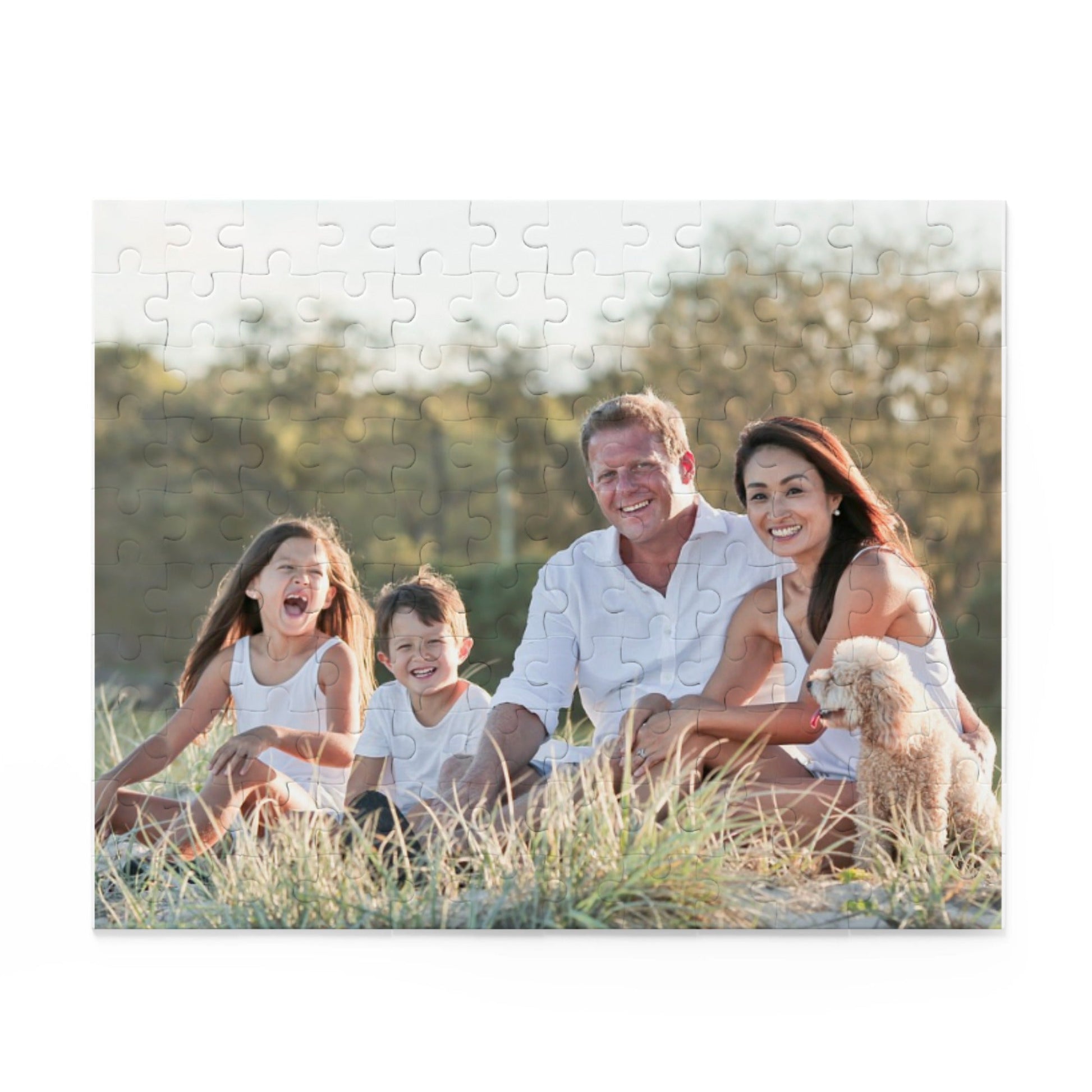 Family sitting on a grassy field with a dog, framed as a puzzle.