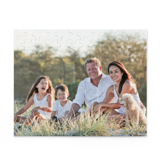 Family sitting on a grassy field with a dog, framed as a puzzle.
