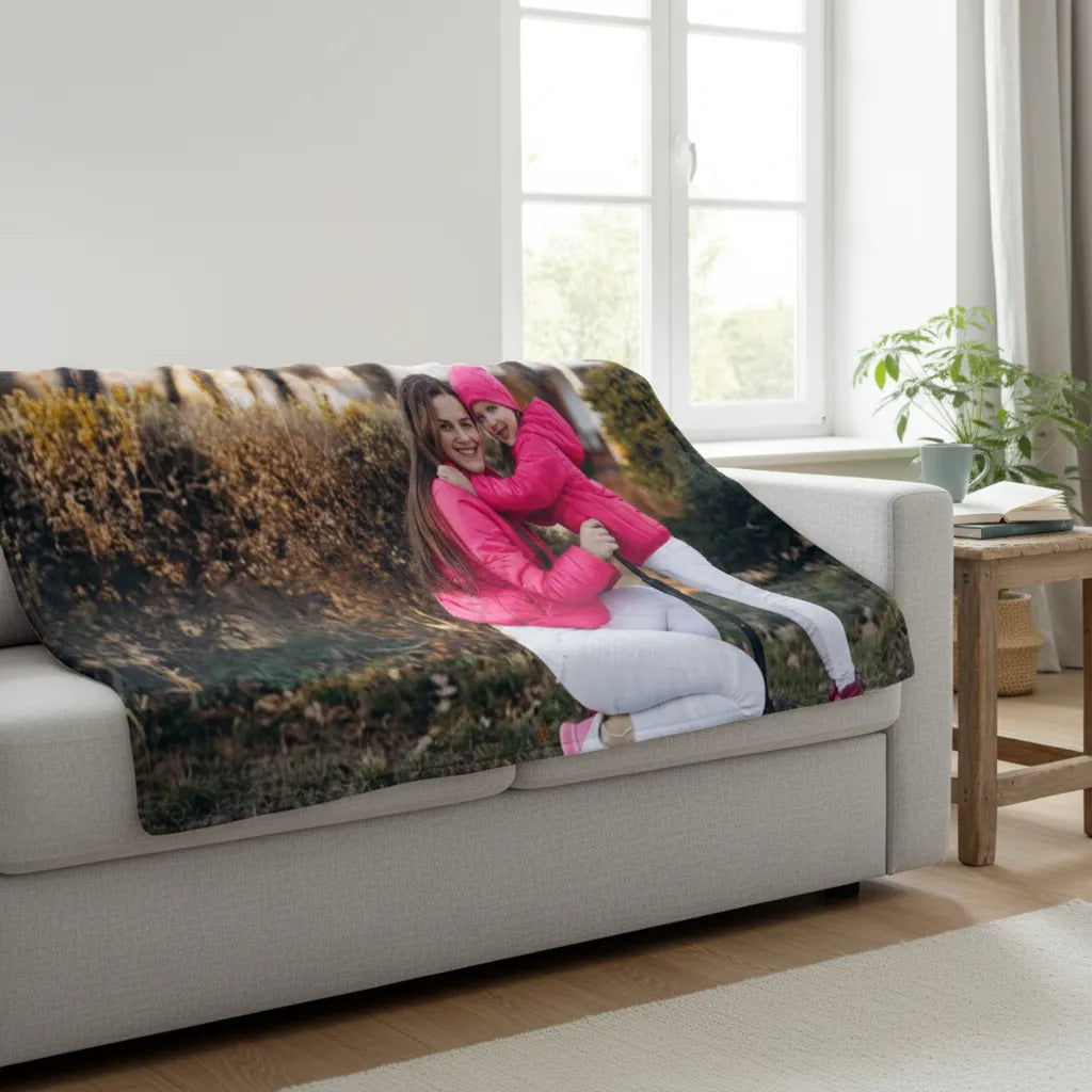 Sofa with a camouflage-patterned blanket featuring two people hugging, in a living room setting.
