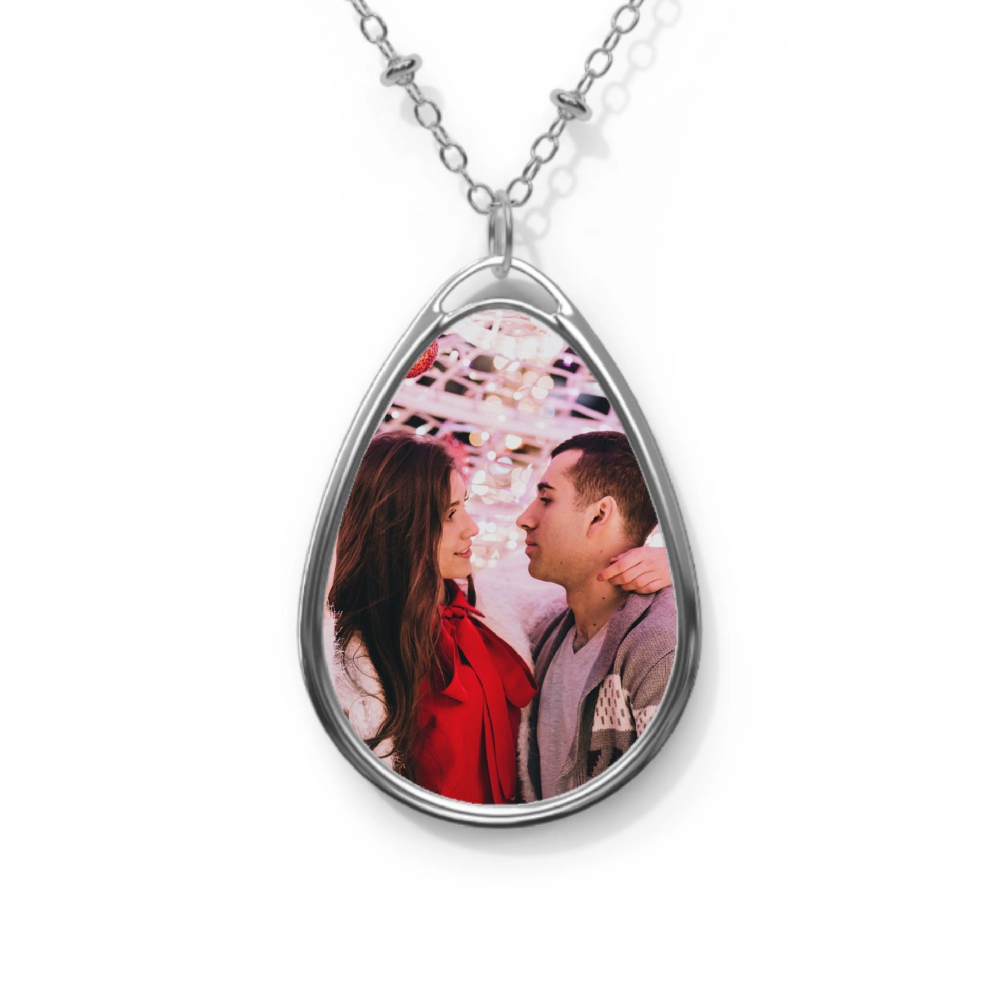 Teardrop-shaped photo pendant with a couple's image on a white background