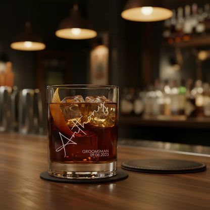 Glass of whiskey with ice on a bar counter, personalized with 'GROOMSMAN' text.