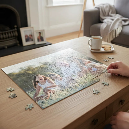 Person working on a puzzle of a girl in a field on a wooden table in a cozy living room.